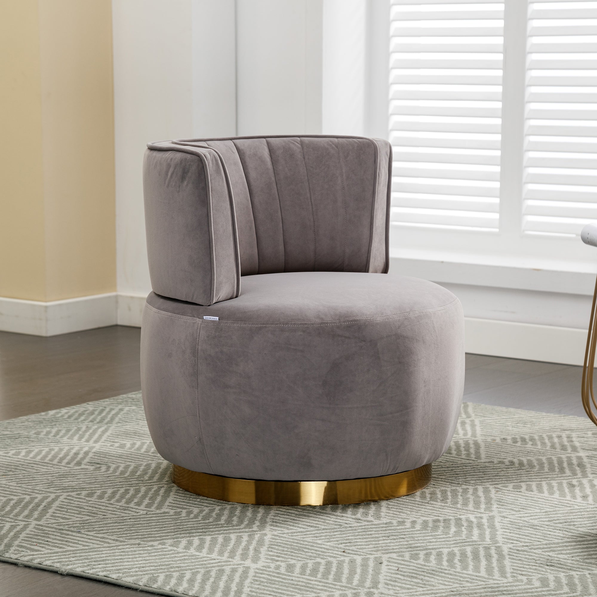 Gray velvet accent chair with 360 degree swivel base — angle view