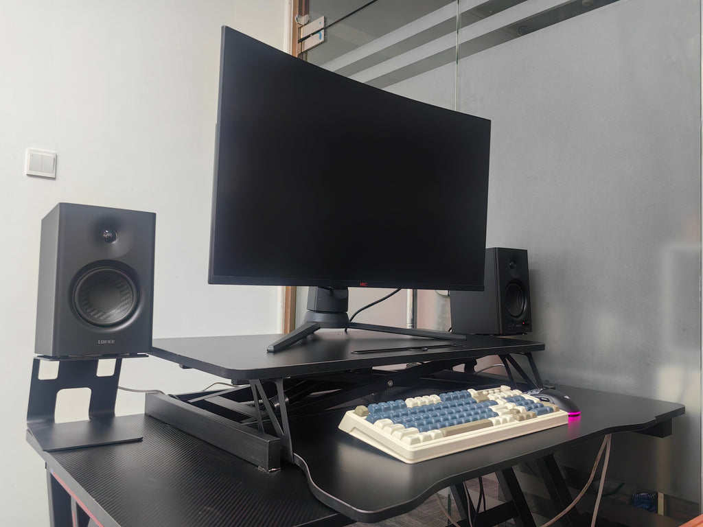 Black desk riser dual monitor setup on home office desk