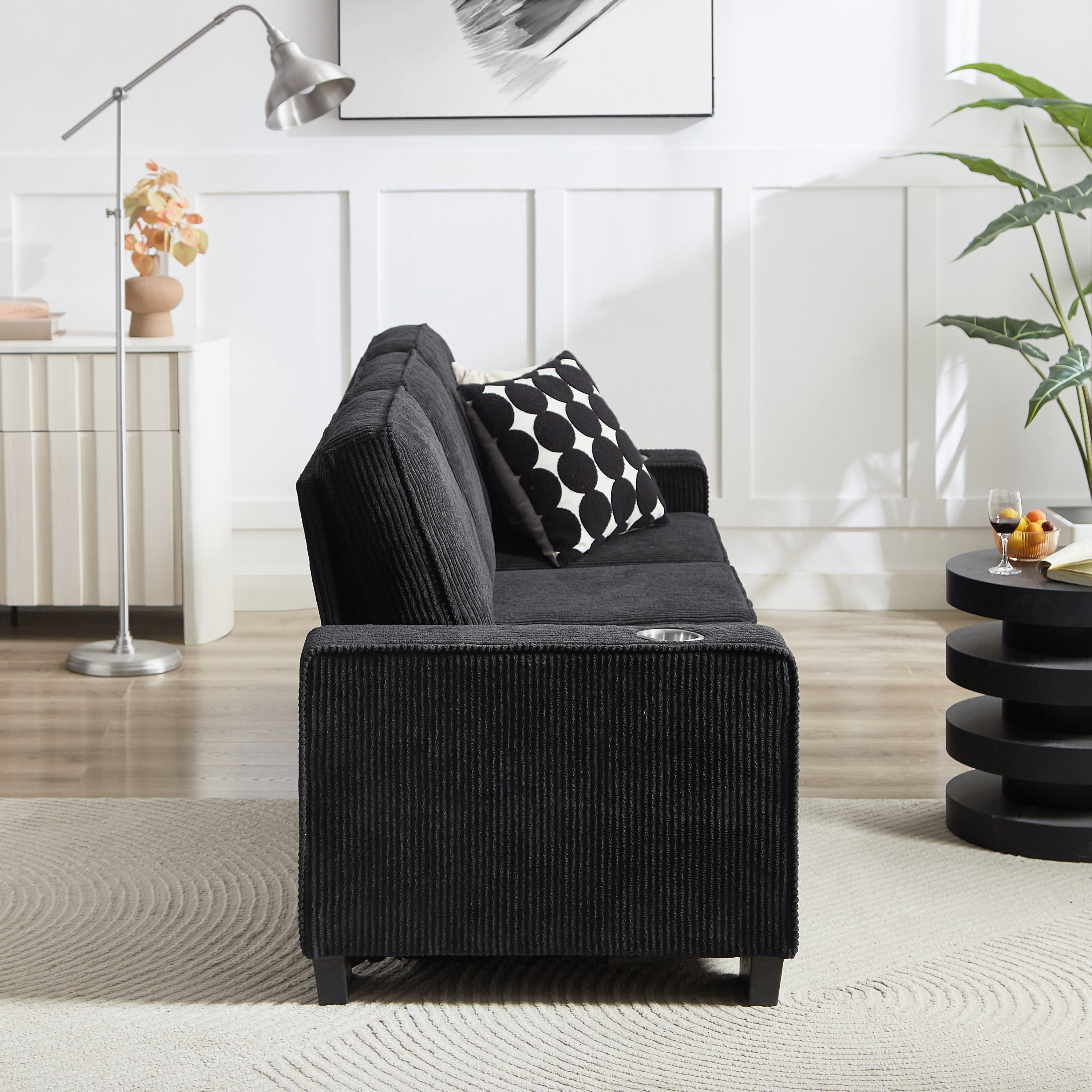Integrated cup holder in black corduroy sofa armrest detail