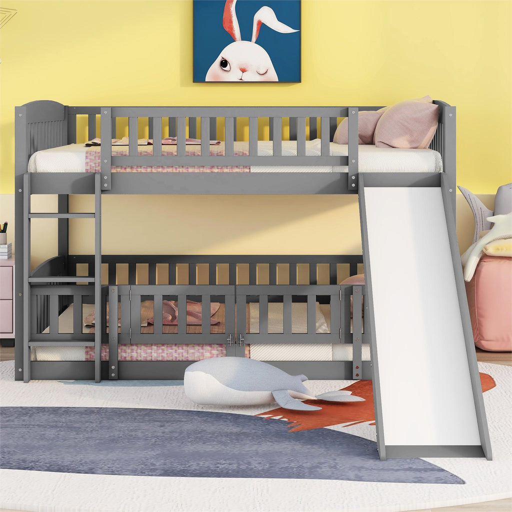 Full over full low bunk bed in gray with built-in slide — angle view