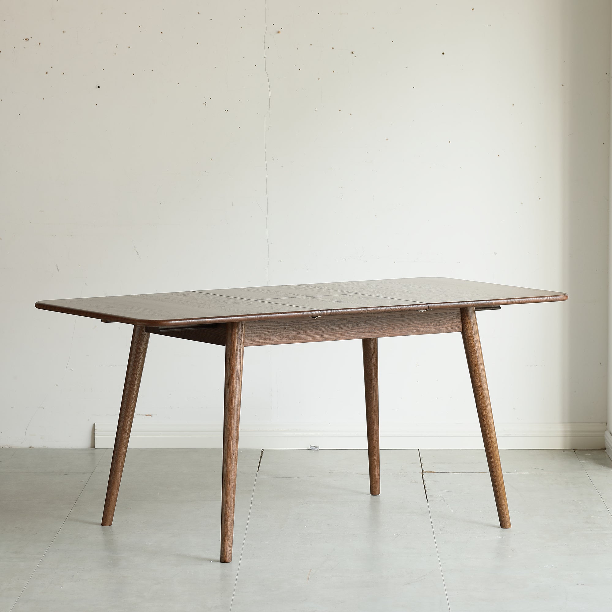 Extendable dining table with round corners and diagonal legs overview