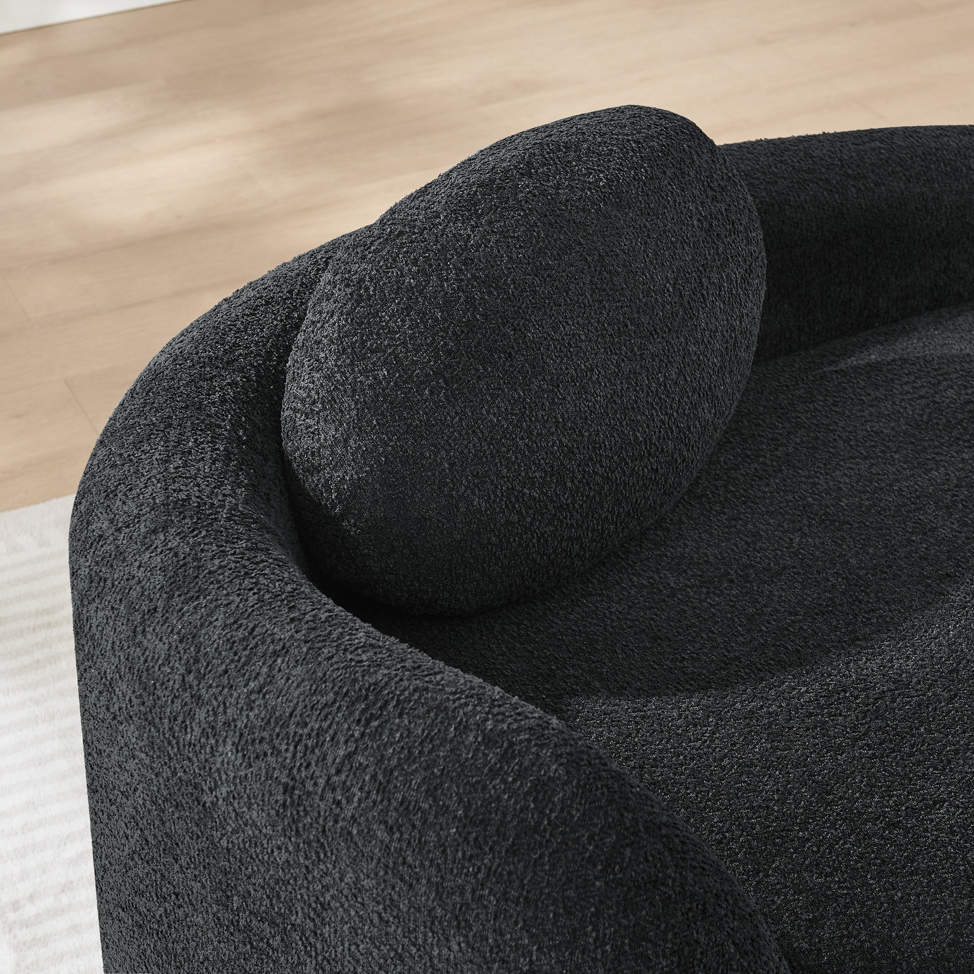 Black bouclé oval chair with pillow for reading nook