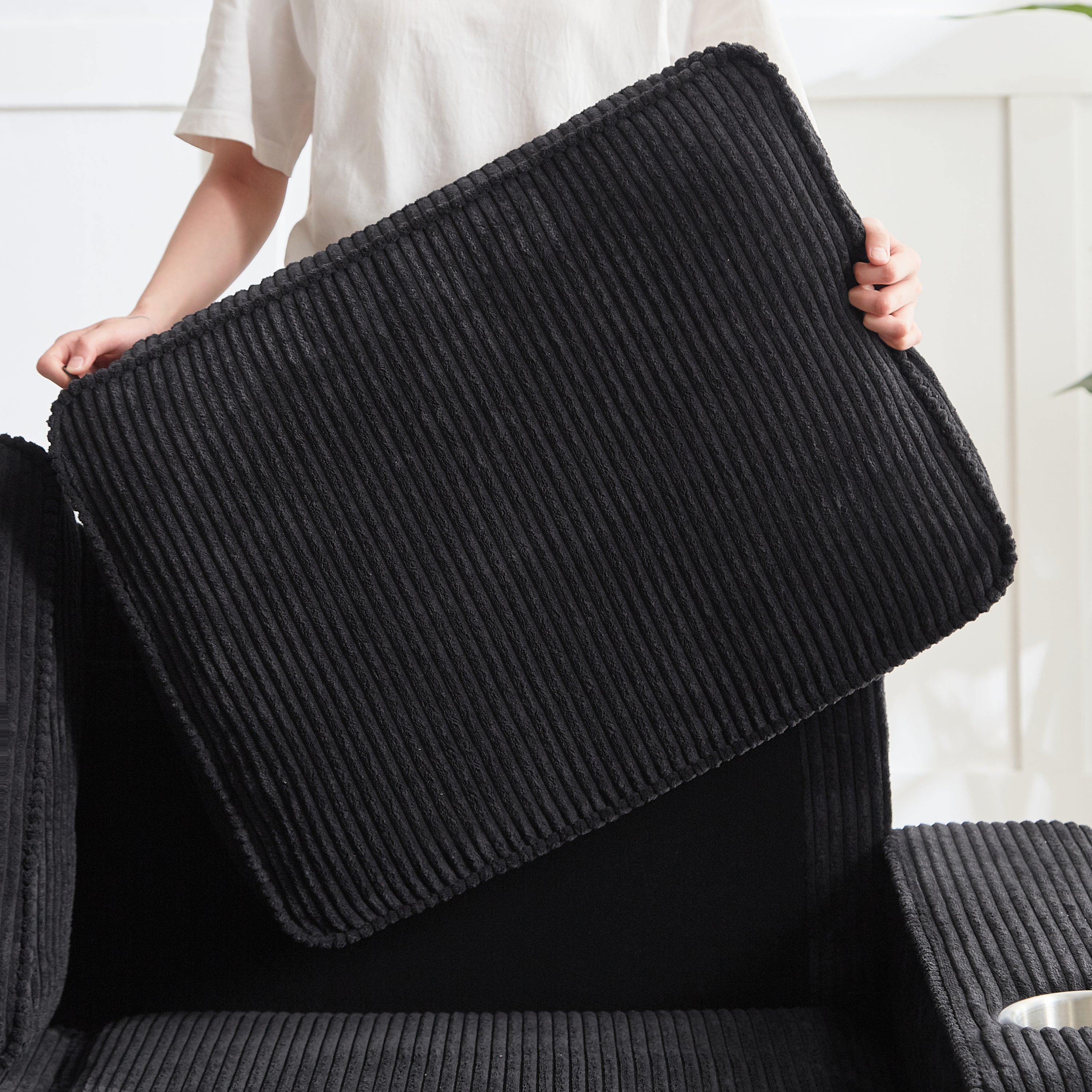Black corduroy compressed couch cushion rebound demonstration