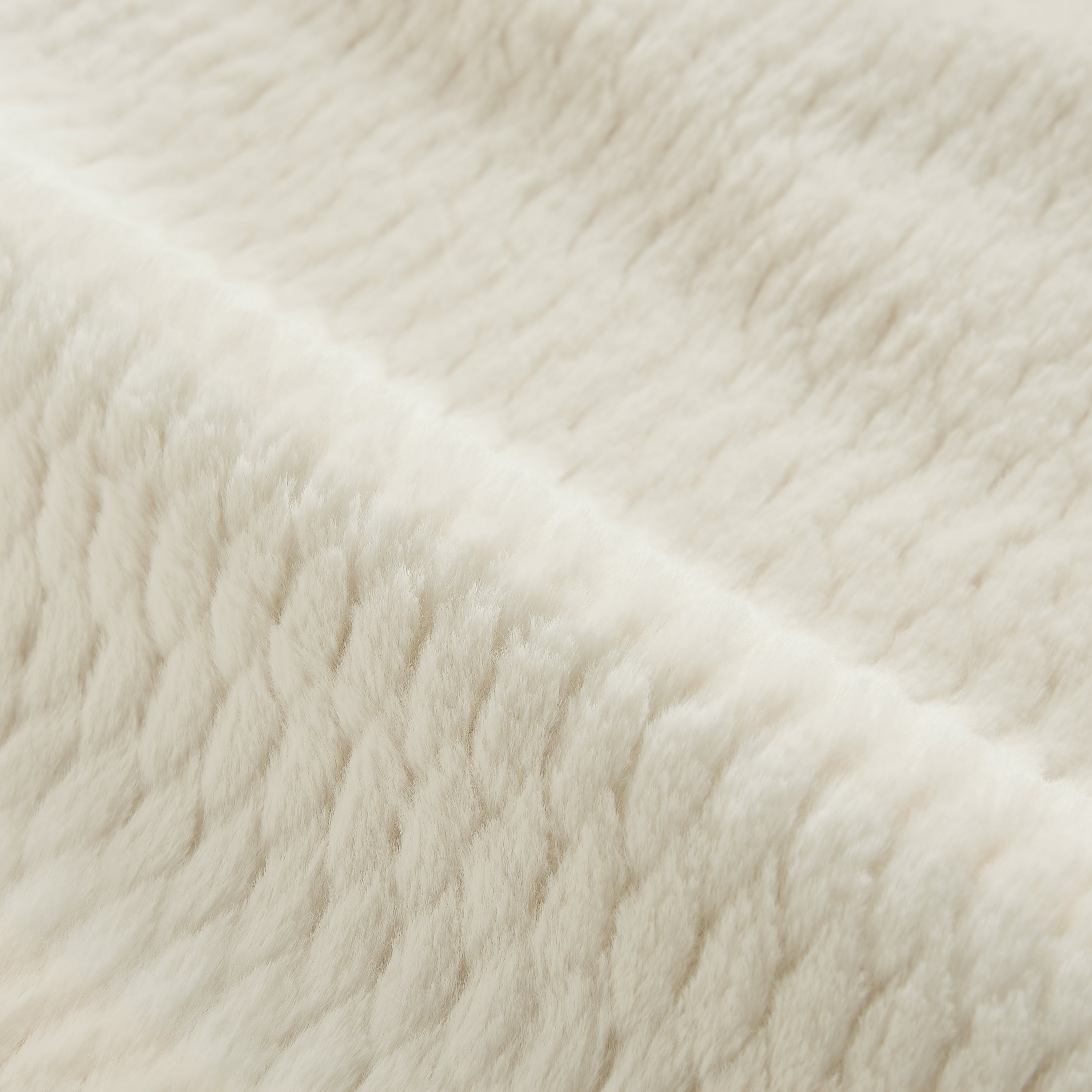 Cream faux fur chair angle view in living room setting