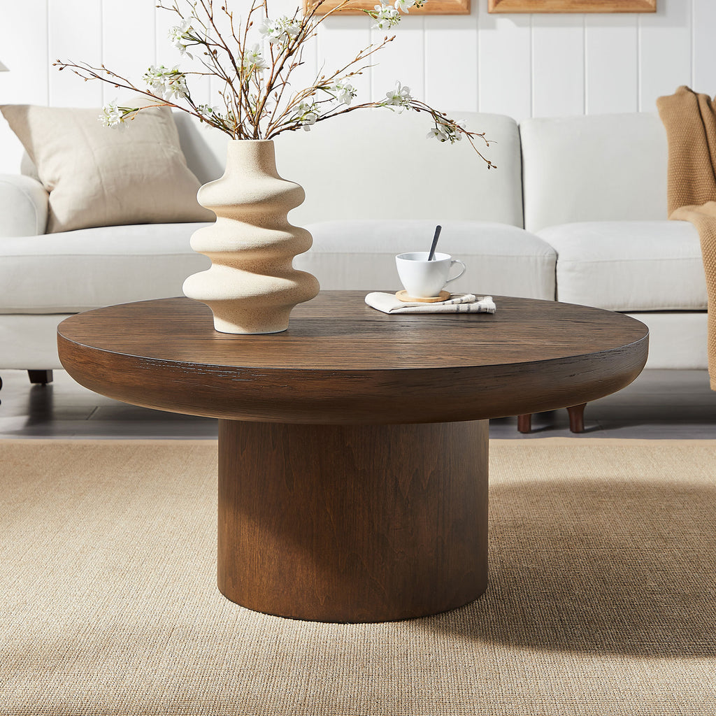 Dark brown round coffee table with cylindrical oak legs — front view