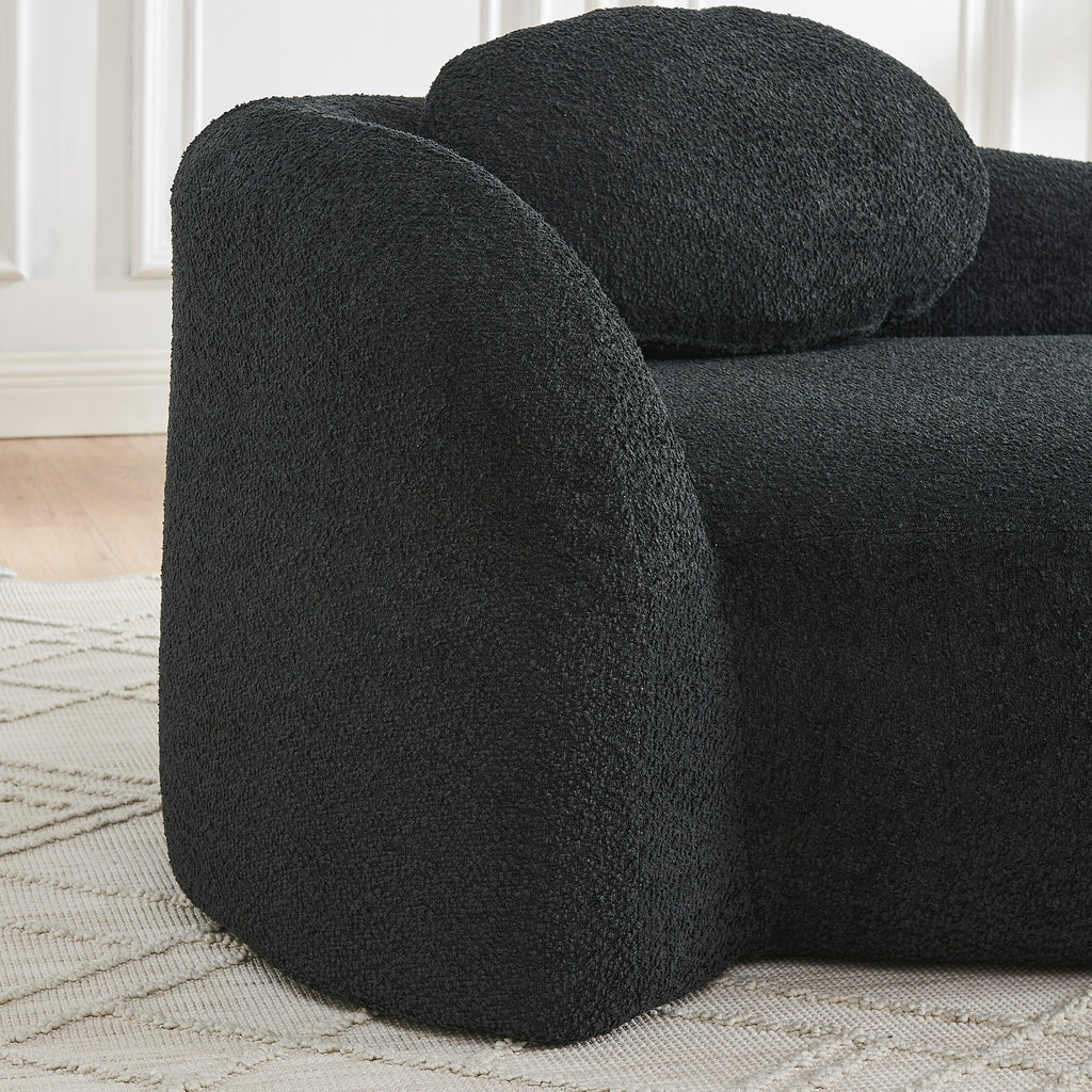 Matching pillow on black bouclé lazy lounge chair backrest