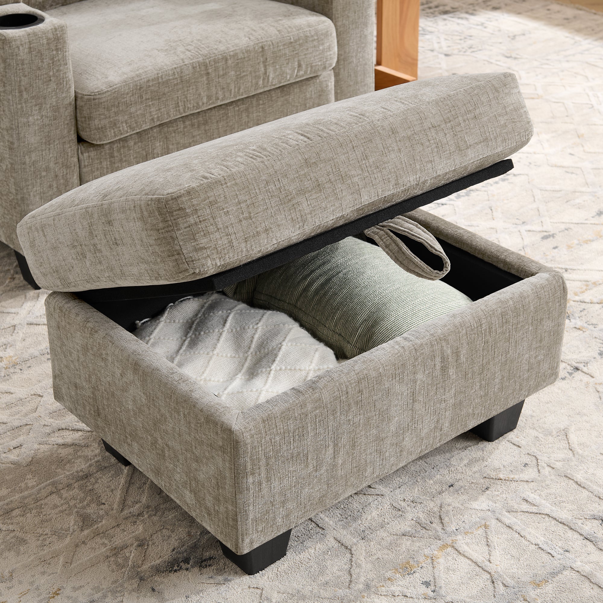 Lift-top storage ottoman beside brown recliner