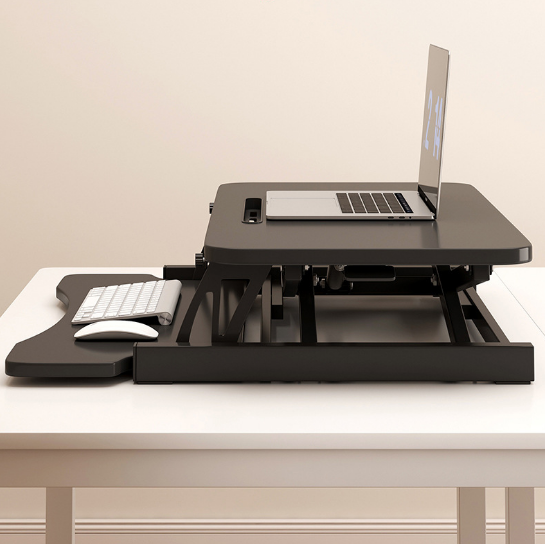 Wide keyboard tray extended on black sit to stand riser
