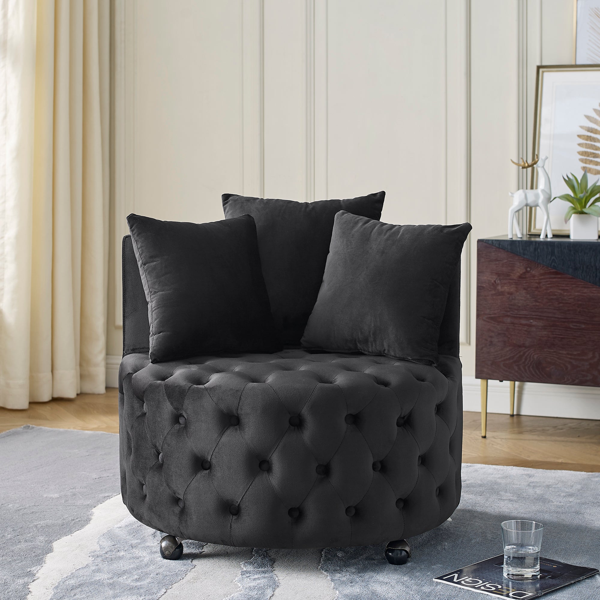 Black velvet tufted swivel chair with 3 pillows in living room