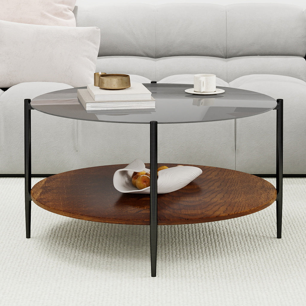 Modern round coffee table black glass top black metal legs — angle view