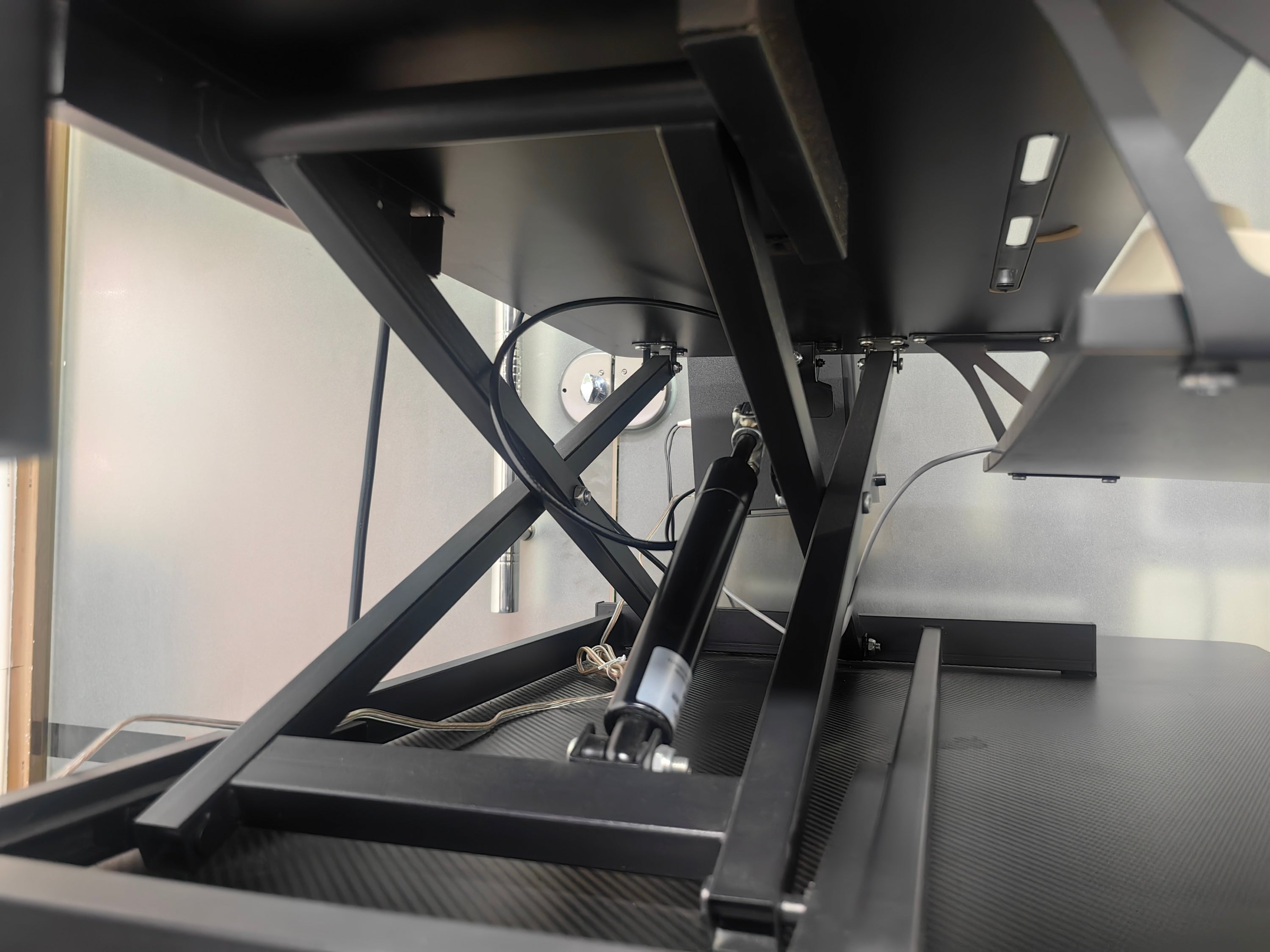 Black standing desk converter in compact study room setting