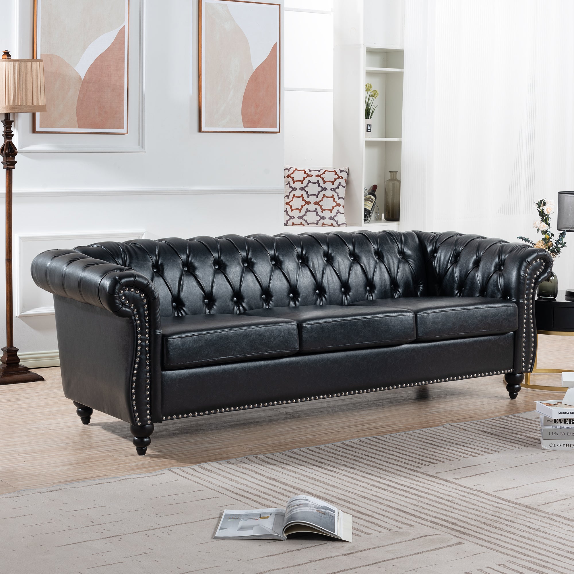 Black Chesterfield sofa with rolled arms — angle view